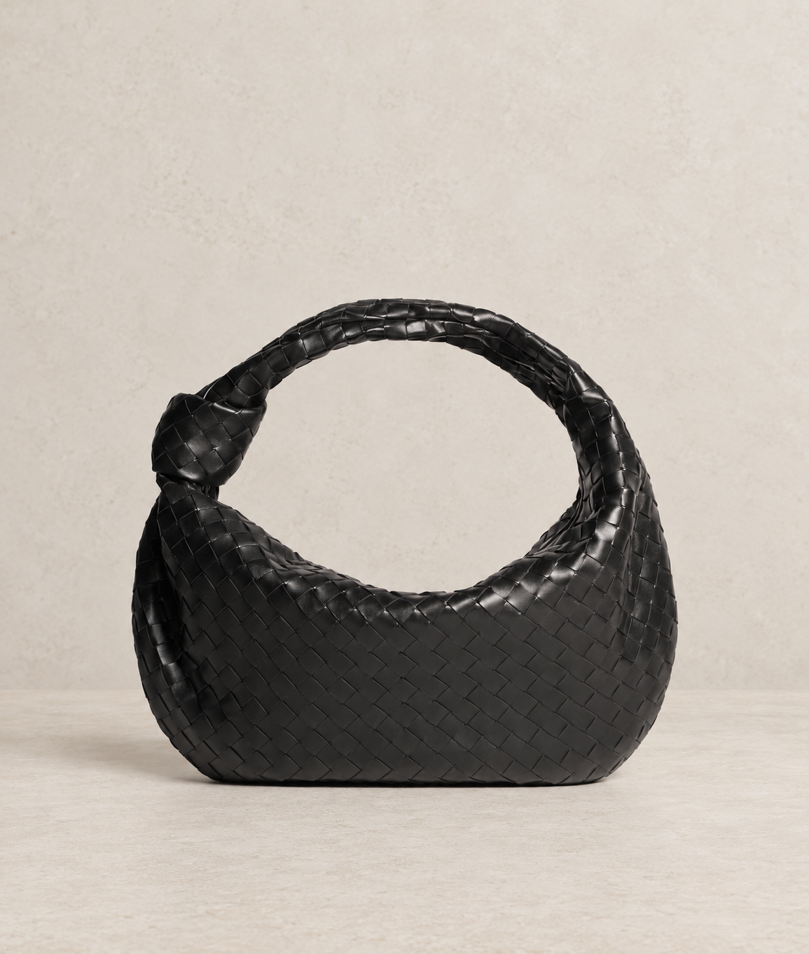 Vista frontal de Siena Negro, bolso hobo de cuero natural de vacuno entrelazado con nudo lateral.
